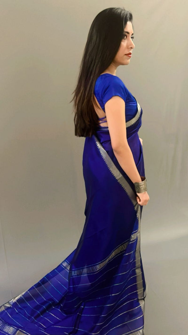 Woman wearing a blue saree with a plain background